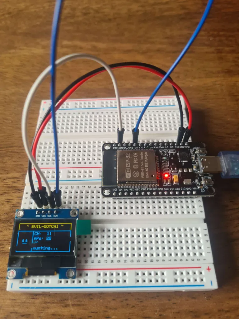 EVIL-GOTCHI prototype on a breadboard with an ESP32 wired to a small OLED